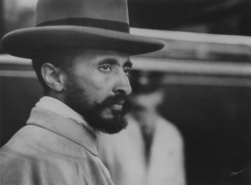 Haile Selassie I of Ethiopia​, a bearded man in a hat, gazes off to the side in this image.