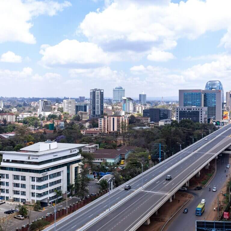 A bustling addis ababa city street with towering buildings in the background, framed by a busy highway.