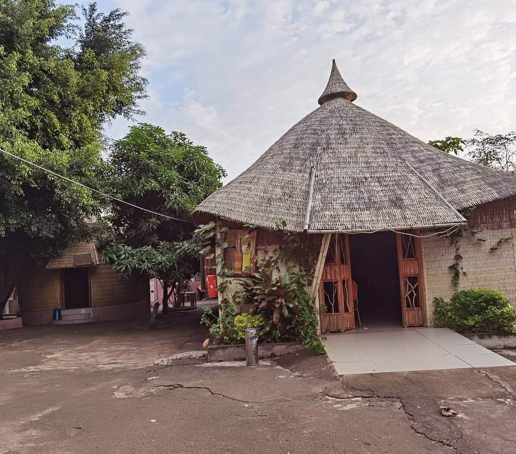  A quaint hut with a thatched roof nestled under a tree at Ezana Arbaminch Hotel.