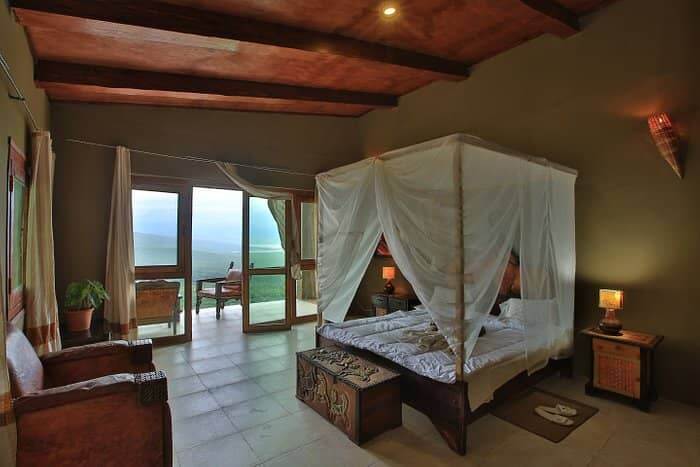 Luxurious canopy bed with ocean backdrop in a bedroom at Emerald Resort.