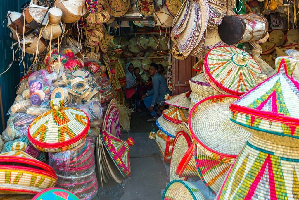 A vibrant Merkato in Addis Ababa, bustling with colorful baskets and hats, showcasing the rich market culture.