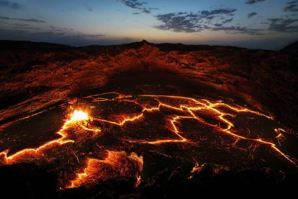 The mesmerizing sight of the lava lake at Erta Ale volcano at sunset, a testament to its historical activity.