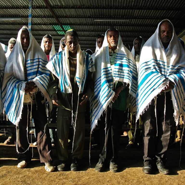A gathering of men donning blue and white shawls, showcasing a sense of unity and cultural attire.