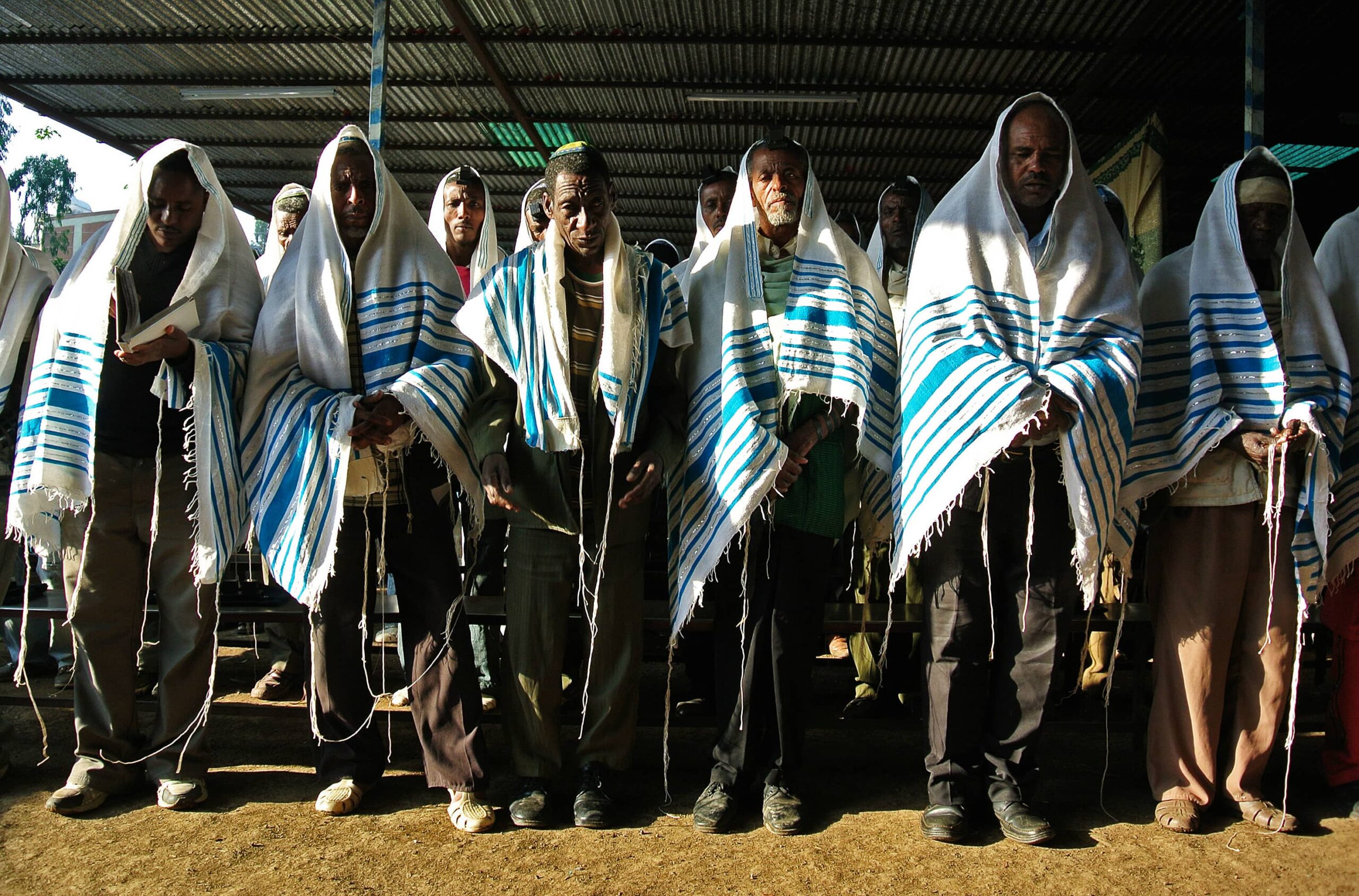 A gathering of men donning blue and white shawls, showcasing a sense of unity and cultural attire.