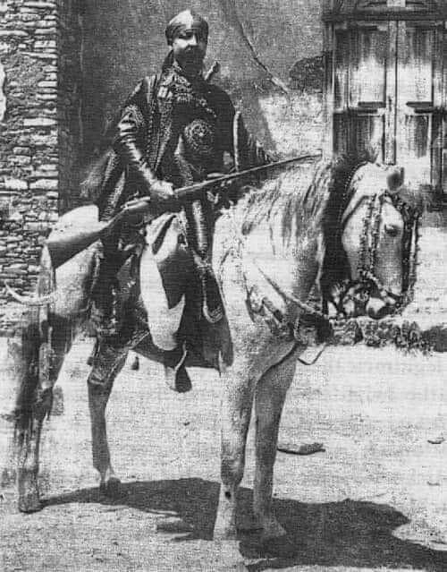An image of a Ras Mengesha Yohannes in traditional clothing gracefully mounted on a horse.