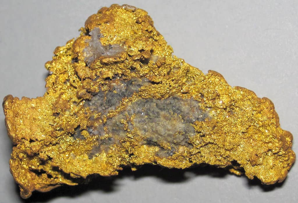 A detailed view of a gleaming gold nugget, showcasing its intricate texture and brilliant color.