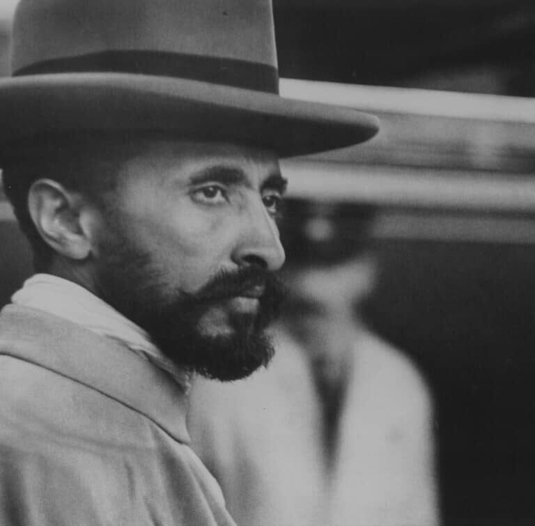 Haile Selassie, a bearded man in a hat, gazes off to the side in this image.