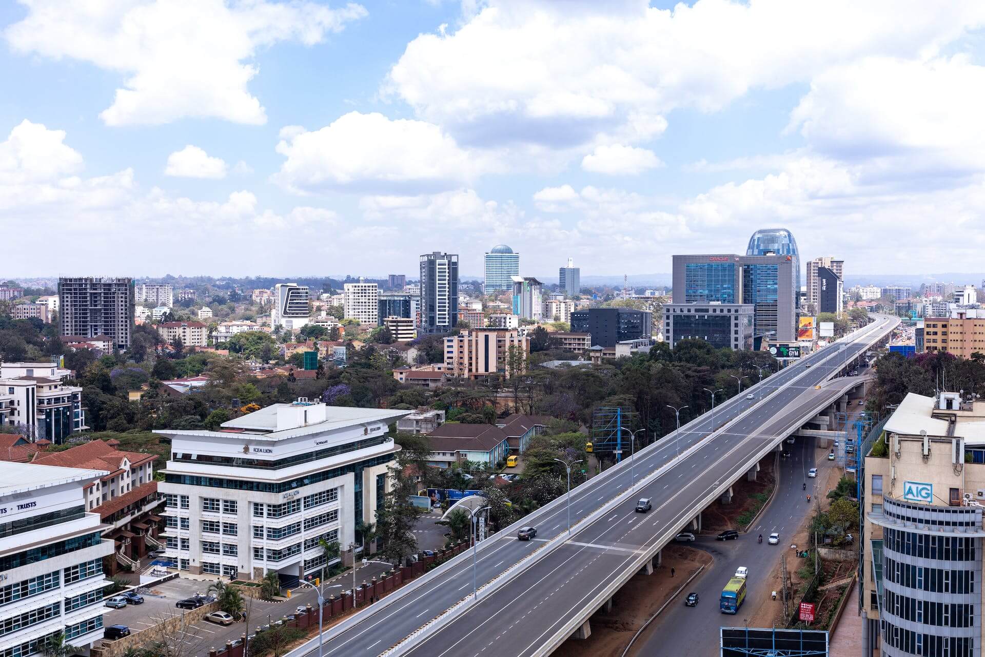 A bustling addis ababa city street with towering buildings in the background, framed by a busy highway.